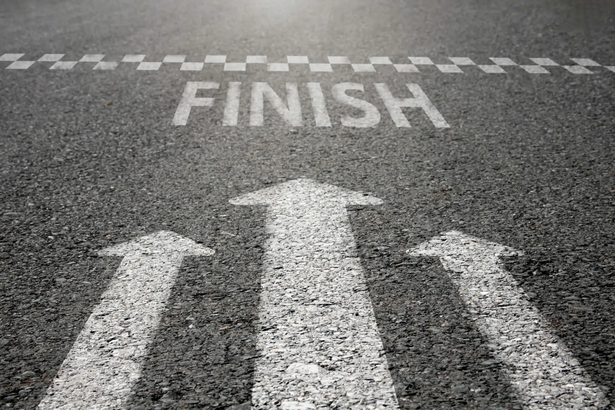 Arrow symbols dash forward to the finish line on the paved road.
