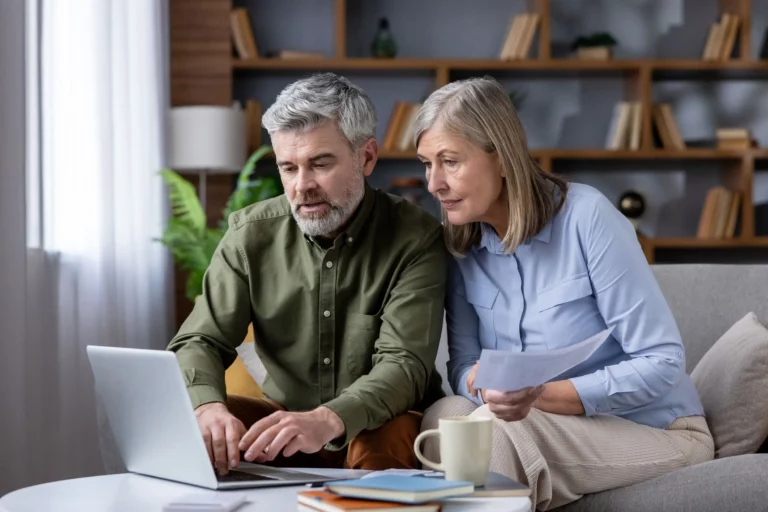 an older couple looks at their finances on a laptop