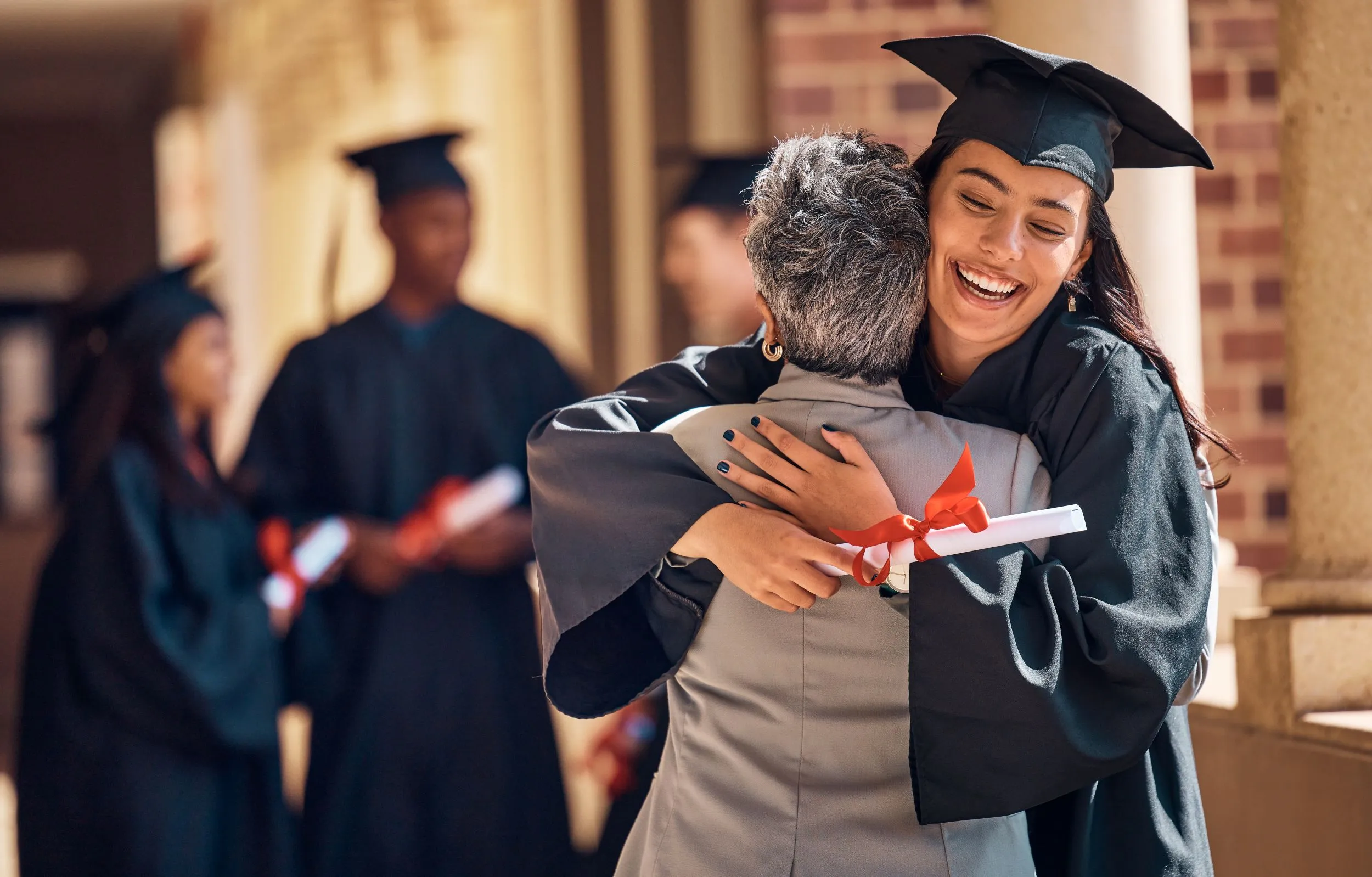 a parent hugs their graduating daughter
