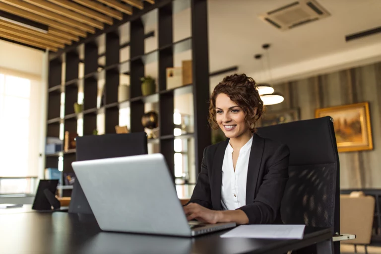 An executive woman working at a desk in an office setting